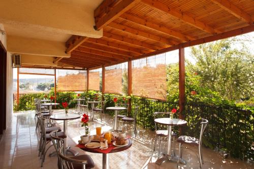 a patio with tables and chairs and windows at Babis Hotel in Skaleta