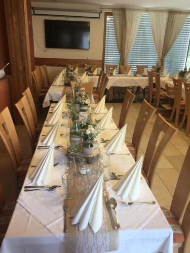 a dining room with long tables with white napkins at Zistelberghof in Werfenweng