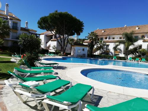 un grupo de tumbonas y una piscina en Carib Playa Marbella apartments en Marbella