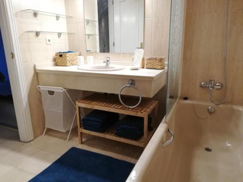 a bathroom with a sink and a mirror and a tub at Carib Playa Marbella apartments in Marbella
