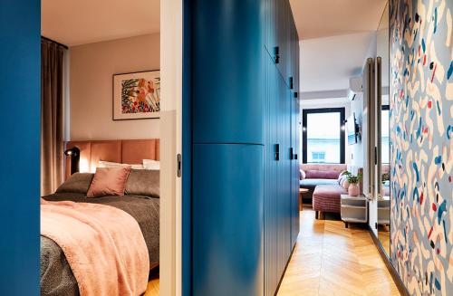 Un dormitorio con una puerta azul y una cama en Rajska Blue Luxury Apartment, en Cracovia
