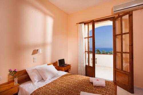 a bedroom with a bed with a view of the ocean at Babis Hotel in Skaleta