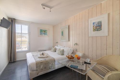 a bedroom with a white bed and a glass table at Le Clos Du GALION - Ile de Ré in Saint-Martin-de-Ré