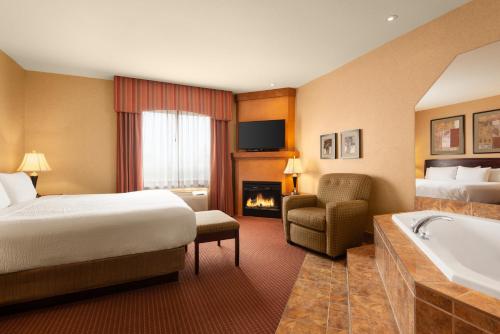 a hotel room with a bed and a bath tub at Days Inn by Wyndham Swift Current in Swift Current