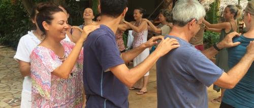 a group of people standing around each other performing a dance at Pousada Morada do Sol in Canoa Quebrada