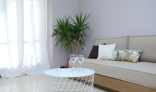 a living room with a couch and a table with wine glasses at Sti Chora Apartments in Lefkada Town