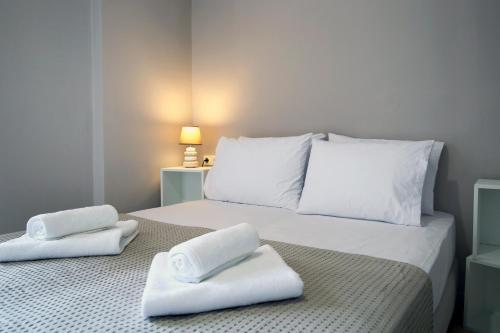a white bed with two towels on top of it at Sti Chora Apartments in Lefkada Town