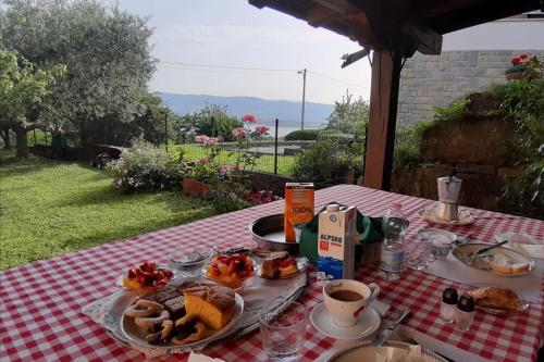 einen Tisch mit Frühstücksspeisen auf einem roten und weißen Tischtuch in der Unterkunft Villa Ambrosia in Muggia