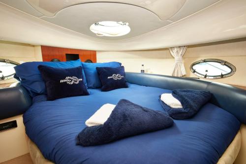 a large blue bed in the middle of a boat at Y-Knot-Two Bedroom Luxury Motor Boat In Lymington in Lymington