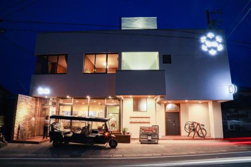 館山市にあるtune Hostel（ツネホステル館山）の夜間の建物前に停車する車