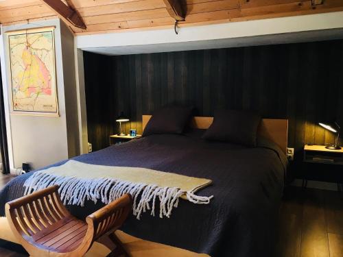 ein Schlafzimmer mit einem großen Bett und einem Stuhl in der Unterkunft Onder de Appelboom in Garminge