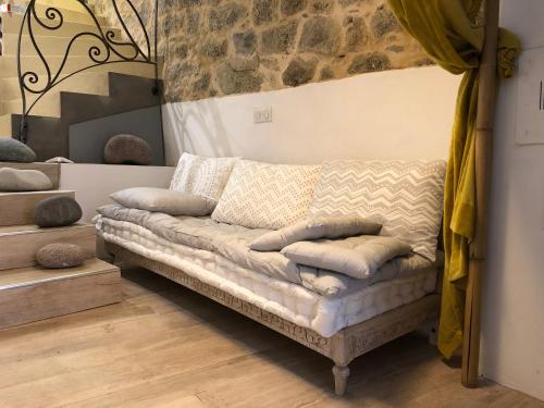 a couch with pillows on it in a room at Lumio petite maison loft vue mer imprenable in Lumio