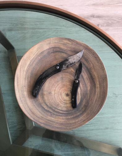 a knife sitting on top of a wooden plate at CORSE - Lumio, Balagne petite maison loft, vue imprenable sur le Golfe de Calvi in Lumio