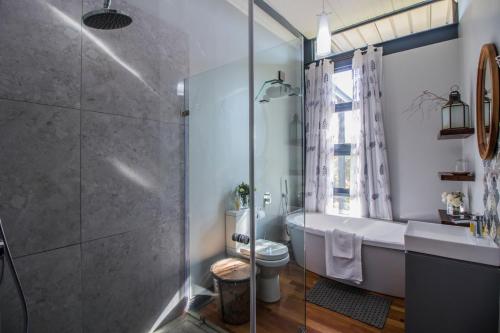 a bathroom with a tub and a toilet and a shower at Wolf Unit in Pretoria