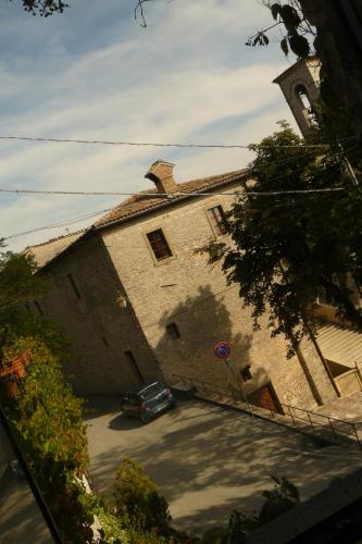 a car parked in front of a building with a tower at Hotel La Rocca in Gubbio