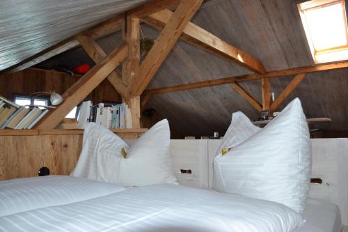 a bedroom with a bed with white pillows at Das Grafengut in Nussdorf am Attersee