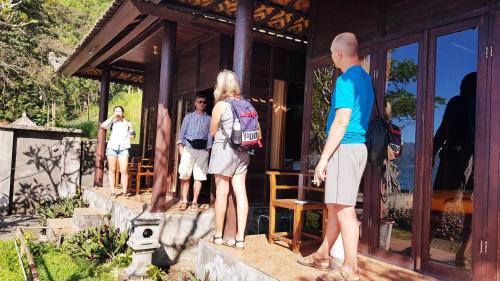 a group of people standing outside of a cabin at Batur Green Lakeview in Kintamani Bali in Kintamani