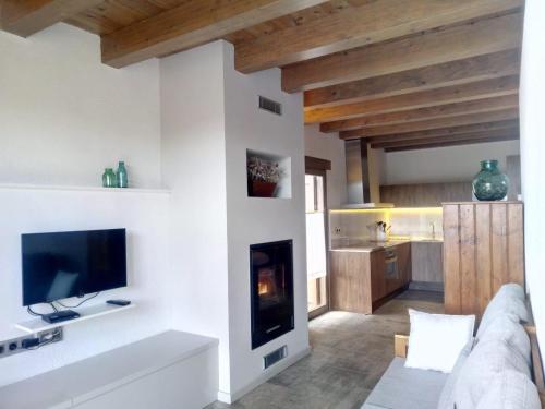 a living room with a tv and a fireplace at Casa Jou in Abella de la Conca