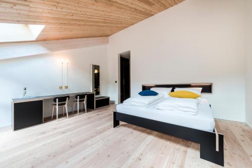 a bedroom with a large bed and a kitchen at Zum Hirschen Boutique Hotel Val di Non in Unsere Liebe Frau im Walde