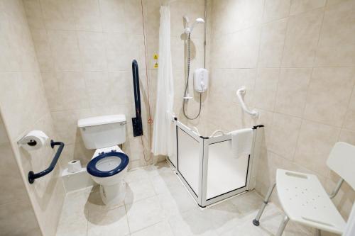 a bathroom with a blue toilet and a shower at Heritage Park Pontypridd, Trademark Collection by Wyndham in Pontypridd
