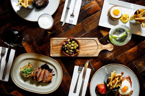 a wooden table with plates of food on it at Heritage Park Pontypridd, Trademark Collection by Wyndham in Pontypridd