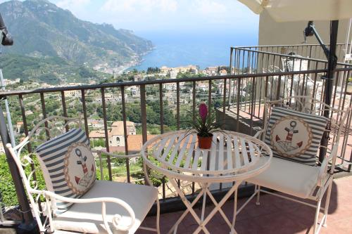 una mesa y sillas en un balcón con vistas en Guest House Malù, en Scala