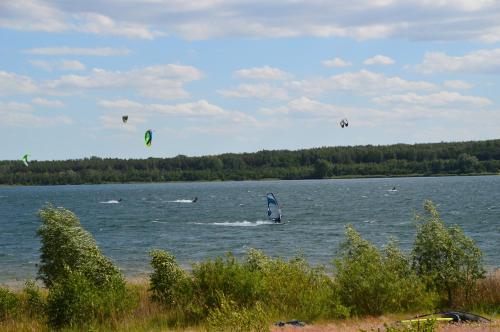 a group of people kite surfing on a lake at Ferienhaus Am Park in Löbnitz