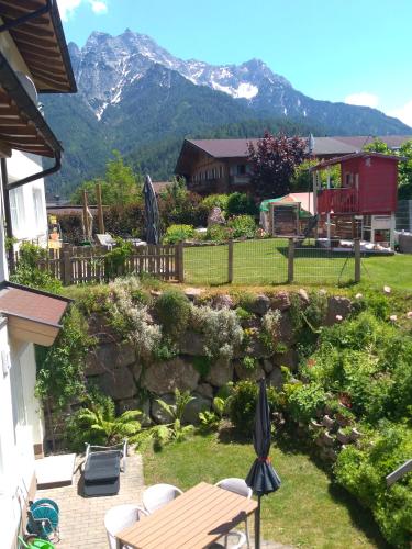 a garden with a table and chairs and mountains in the background at Ferienwohnung Zechner in Waidring