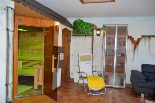 a living room with a yellow chair and a glass door at Ferienhaus Am Park in Löbnitz