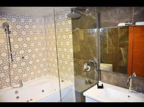 a bathroom with a shower and a tub and a sink at AKBAK OTEL in Çankırı