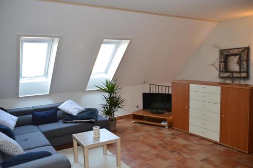 ein Wohnzimmer mit einem blauen Sofa und einem TV in der Unterkunft Ferienhaus Am Park in Löbnitz