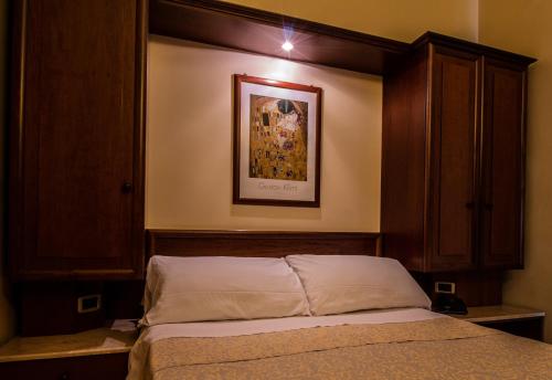 a bedroom with a bed and a picture on the wall at Hotel Gangi in Piazza Armerina