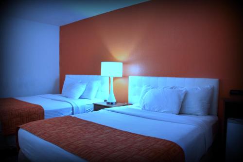 a hotel room with two beds and a lamp at Howard Johnson by Wyndham Roseburg in Roseburg