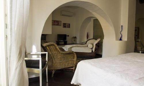 a bedroom with a bed and chairs in a room at Cà d'Estrina in Bonassola