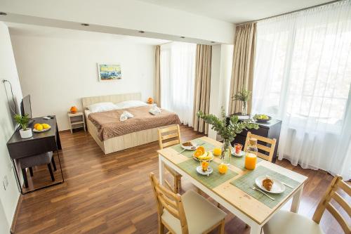 a living room with a bed and a dining room table at Villa Gréta in Siófok