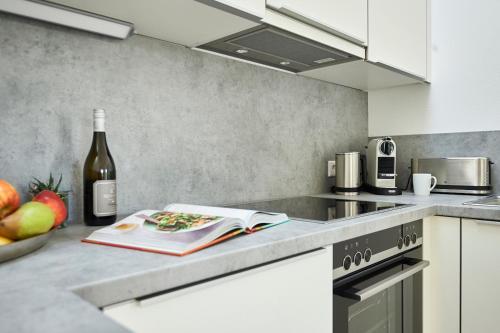 a kitchen with a bottle of wine and a book at Boardinghome Oldenburg in Oldenburg