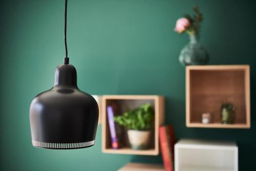 a black pendant light hanging from a blue wall at Boardinghome Oldenburg in Oldenburg