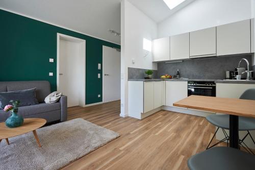 a kitchen and living room with a couch and a table at Boardinghome Oldenburg in Oldenburg