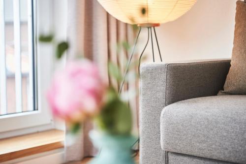 a vase of flowers sitting next to a couch at Boardinghome Oldenburg in Oldenburg