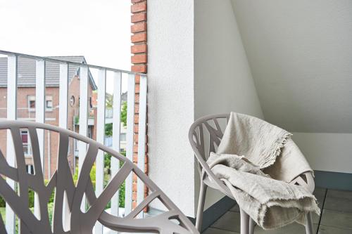 a chair with a blanket sitting on a balcony at Boardinghome Oldenburg in Oldenburg