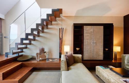 a living room with a staircase and a couch at Hyatt Regency Barcelona Tower in Hospitalet de Llobregat