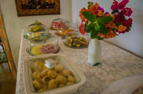 カノア・ケブラーダにあるPousada Morada do Solの食べ物のトレイと花瓶
