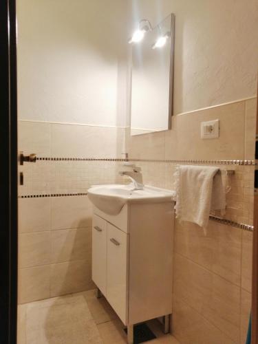 a white bathroom with a sink and a mirror at Casa Emma in Krk