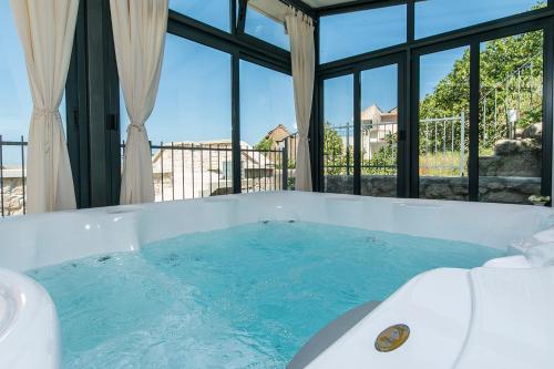 a bath tub filled with blue water in a room at Old stone house Mario in Podgora