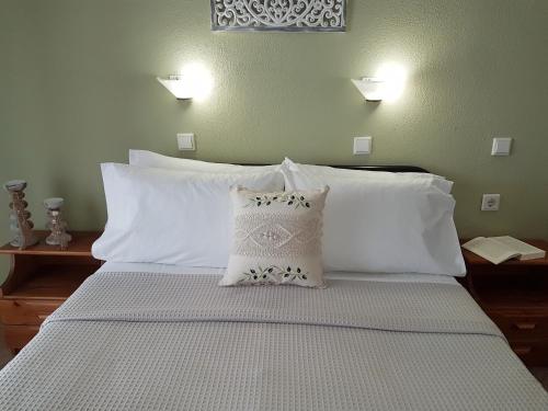 ein Schlafzimmer mit einem Bett mit weißen Kissen in der Unterkunft Lina Studios in Potos