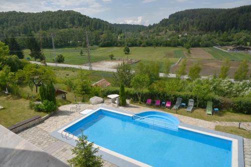 a swimming pool with a view of a field and mountains at Hotel Zenit Satovcha in Satovcha