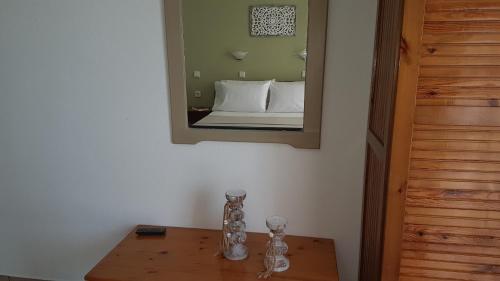 Zimmer mit einem Spiegel und einem Tisch mit einem Bett in der Unterkunft Lina Studios in Potos