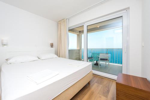 a bedroom with a bed and a large window at Sea Sky Apartment in Cavtat