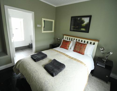 a bedroom with a large bed with two pillows on it at The Old Cottage in Doolin