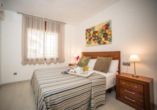 a bedroom with a bed with a tray of food on it at Ona Jardines Paraisol in Salou